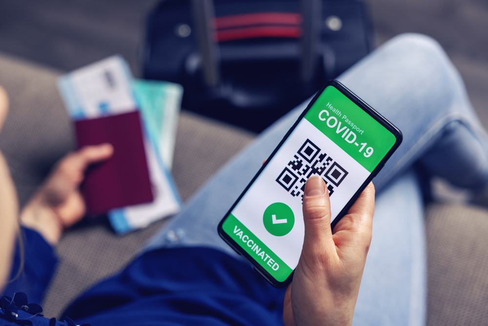휴대폰으로 백신증명서를 보고 있는 여행객 